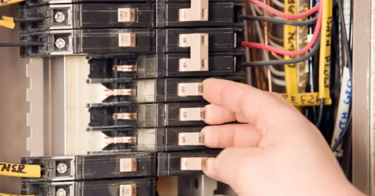 man adjusting electrical panel