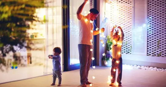 family putting up holiday lights